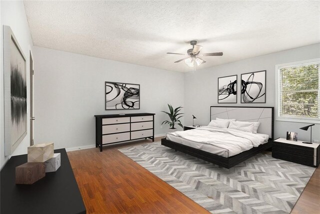 7002 Spout Springs Rd, Flowery Branch, GA 30542 - unfurnished bedroom featuring a spacious closet, wood finished floors, a closet, a textured ceiling, and a ceiling fan