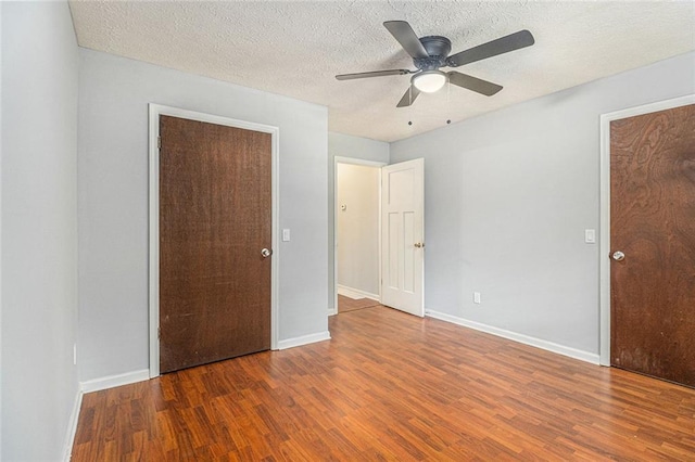 7002 Spout Springs Rd, Flowery Branch, GA 30542 - unfurnished bedroom featuring wood finished floors, a textured ceiling, and a ceiling fan