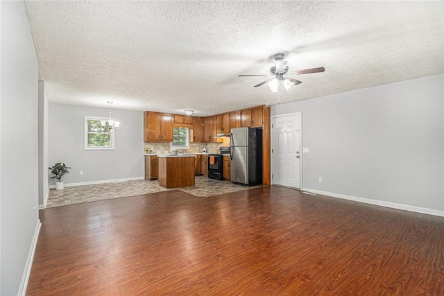 7002 Spout Springs Rd, Flowery Branch, GA 30542 - kitchen with freestanding refrigerator, open floor plan, black range with electric cooktop, dark wood-type flooring, and a textured ceiling