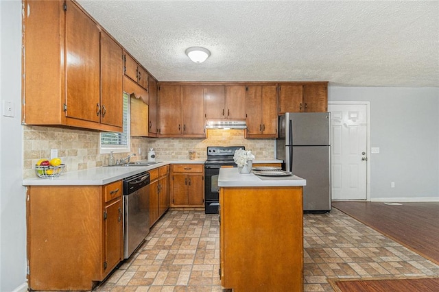 7002 Spout Springs Rd, Flowery Branch, GA 30542 - kitchen with appliances with stainless steel finishes, under cabinet range hood, backsplash, a center island, and brown cabinetry