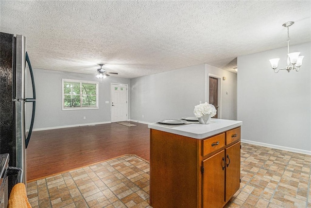7002 Spout Springs Rd, Flowery Branch, GA 30542 - kitchen with stainless steel appliances, a ceiling fan, light countertops, a chandelier, and brown cabinetry