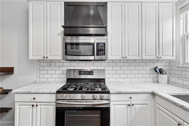 872 Briarcliff Rd NE Unit B2, Atlanta, GA 30306 - kitchen featuring appliances with stainless steel finishes, extractor fan, white cabinets, backsplash, and light stone counters