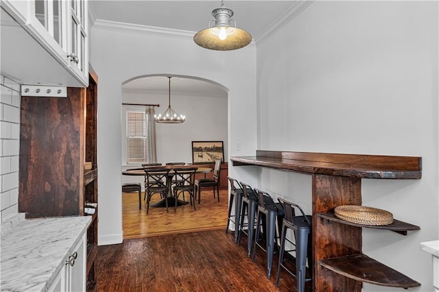 872 Briarcliff Rd NE Unit B2, Atlanta, GA 30306 - dining room featuring crown molding, arched walkways, dark wood-style floors, and a chandelier