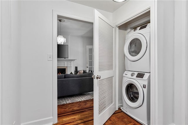 872 Briarcliff Rd NE Unit B2, Atlanta, GA 30306 - laundry room featuring stacked washer and clothes dryer, a lit fireplace, and a chandelier