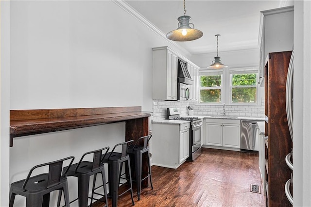 872 Briarcliff Rd NE Unit B2, Atlanta, GA 30306 - kitchen with appliances with stainless steel finishes, ornamental molding, backsplash, pendant lighting, and dark wood-style flooring