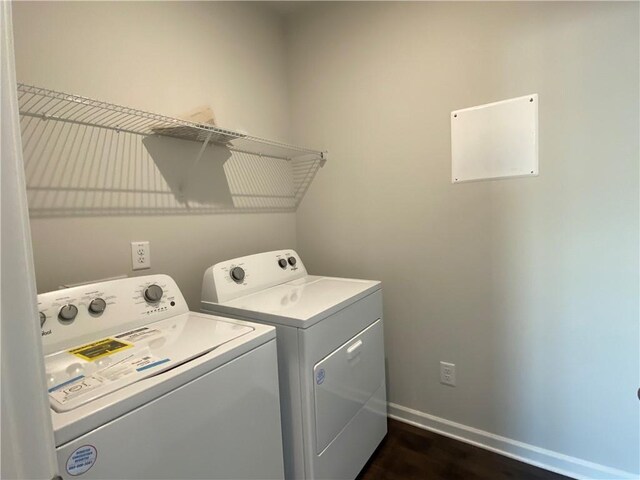 washroom with separate washer and dryer and dark hardwood / wood-style flooring