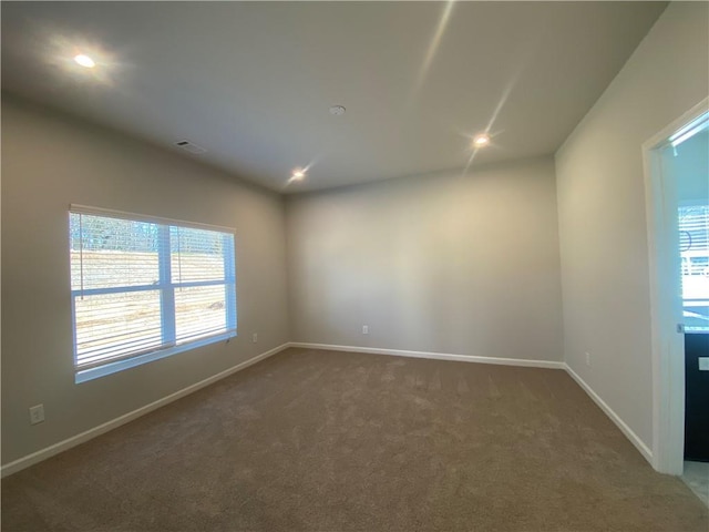 unfurnished room featuring dark carpet and lofted ceiling