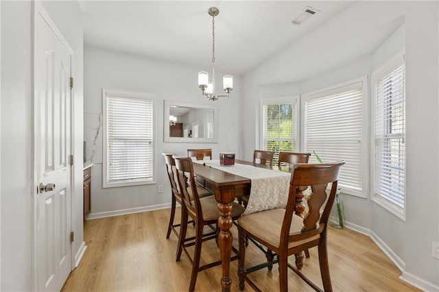 dining room featuring light wood-style flooring, an inviting chandelier, baseboards, and visible vents
