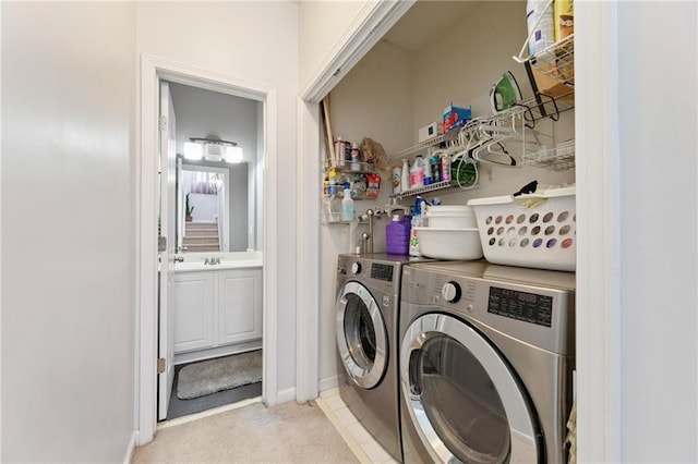 laundry area featuring a sink, washer and dryer, laundry area, and light carpet