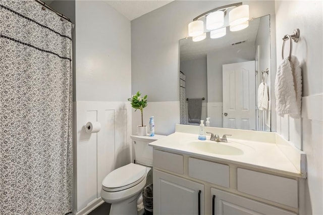 bathroom with visible vents, toilet, curtained shower, and vanity