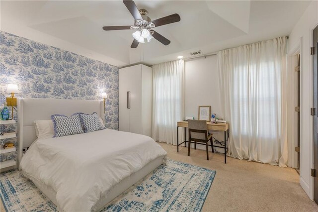 bedroom featuring a ceiling fan, multiple windows, visible vents, and carpet floors