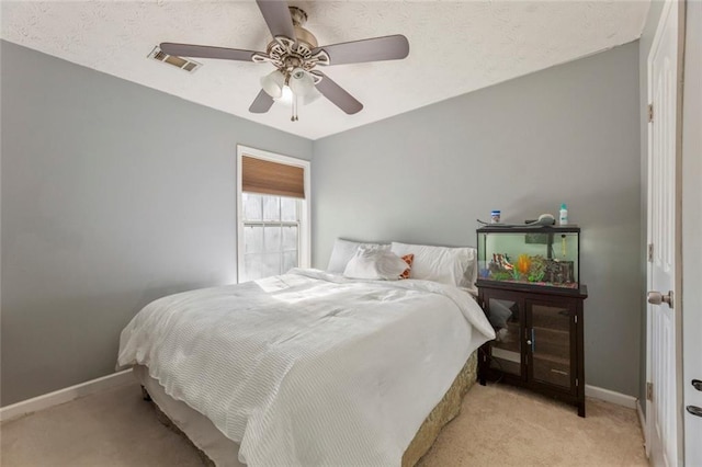 bedroom with ceiling fan, light colored carpet, baseboards, and visible vents