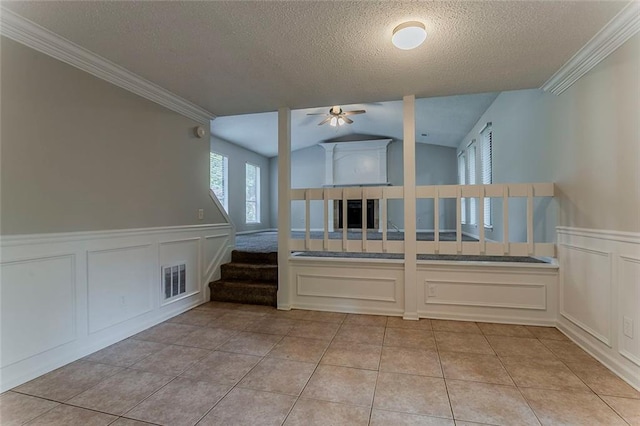 5383 Forest E Ln, Stone Mountain, GA 30088 - empty room featuring a decorative wall, a textured ceiling, ceiling fan, stairs, and wainscoting