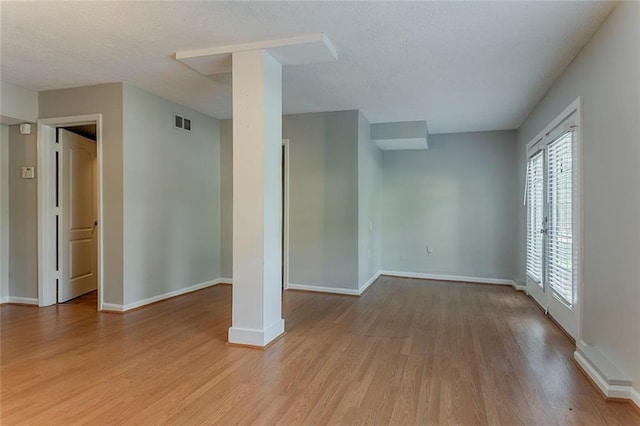 5383 Forest E Ln, Stone Mountain, GA 30088 - spare room with light wood-style floors, ornate columns, and a textured ceiling