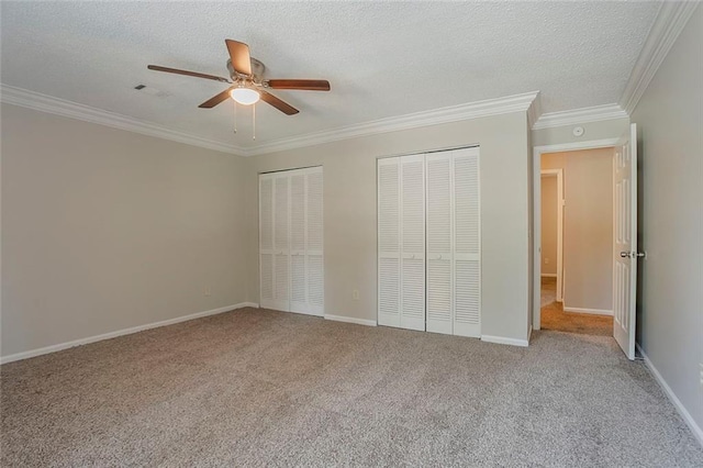 5383 Forest E Ln, Stone Mountain, GA 30088 - unfurnished bedroom featuring two closets, carpet floors, ornamental molding, a textured ceiling, and ceiling fan