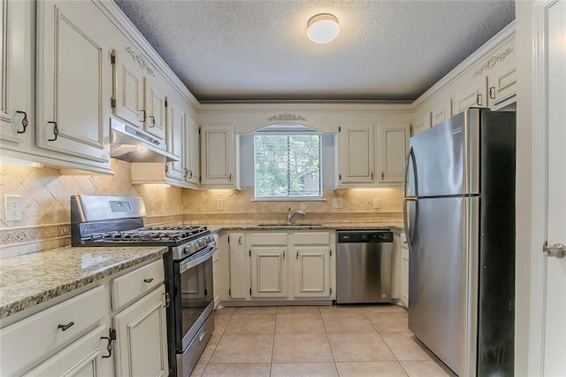 5383 Forest E Ln, Stone Mountain, GA 30088 - kitchen featuring appliances with stainless steel finishes, under cabinet range hood, a textured ceiling, light tile patterned flooring, and tasteful backsplash