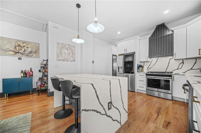 kitchen with backsplash, stainless steel appliances, light stone countertops, and light wood-style floors