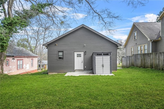 back of house with a lawn and fence