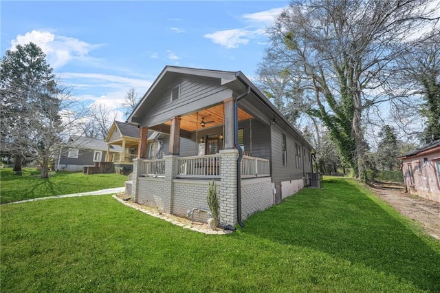 view of property exterior featuring central AC, covered porch, a ceiling fan, and a yard