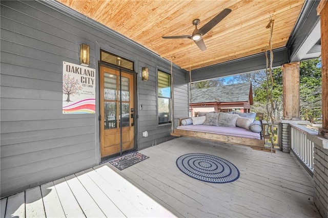 wooden deck with a porch and ceiling fan