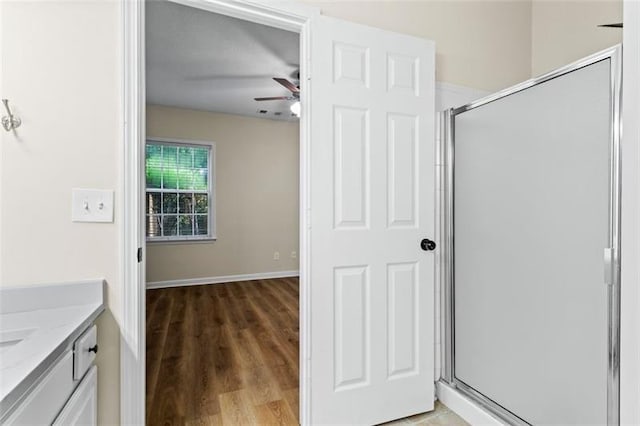 bathroom featuring vanity, hardwood / wood-style flooring, ceiling fan, and a shower with shower door