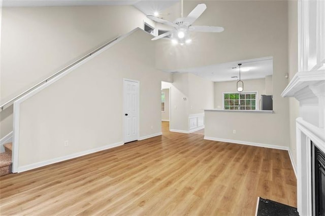 unfurnished living room featuring light hardwood / wood-style floors, ceiling fan, and lofted ceiling