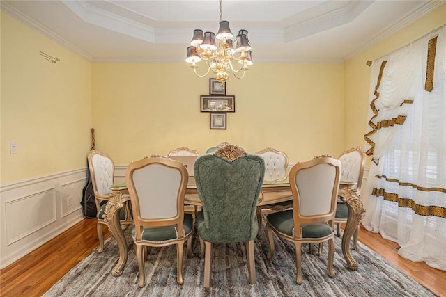 1644 Beaver Creek Ln, Snellville, GA 30078 - dining area with wood finished floors, a chandelier, a raised ceiling, ornamental molding, and wainscoting