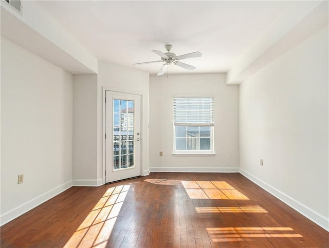 spare room featuring hardwood / wood-style floors, baseboards, visible vents, and ceiling fan