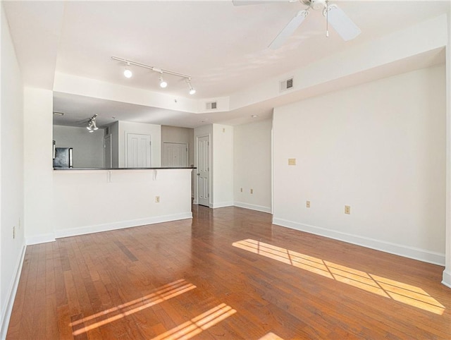 spare room featuring visible vents, a ceiling fan, baseboards, and wood-type flooring