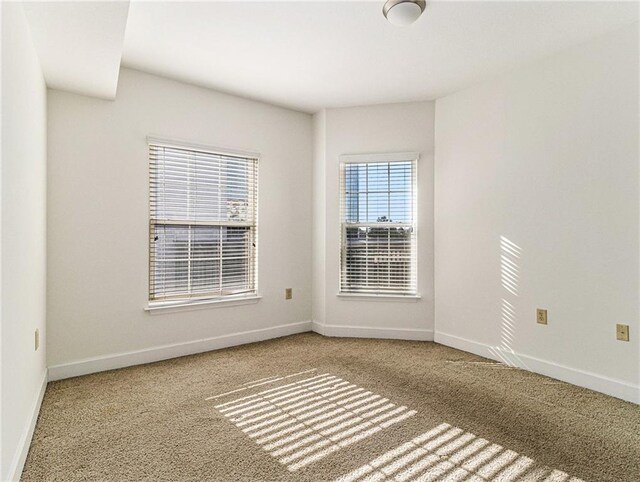 carpeted empty room with baseboards