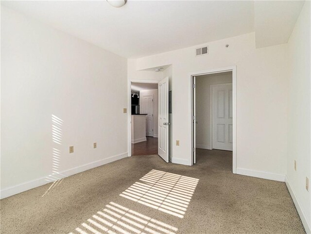 unfurnished bedroom featuring visible vents, baseboards, and carpet floors