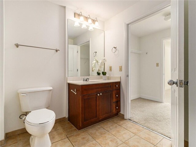 bathroom with vanity, tile patterned floors, toilet, and baseboards