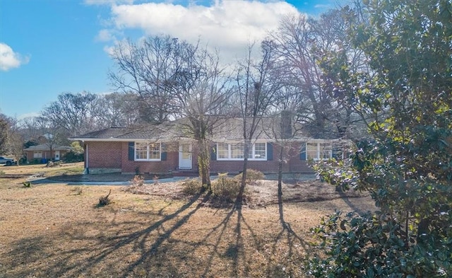 ranch-style house featuring brick siding and a front yard