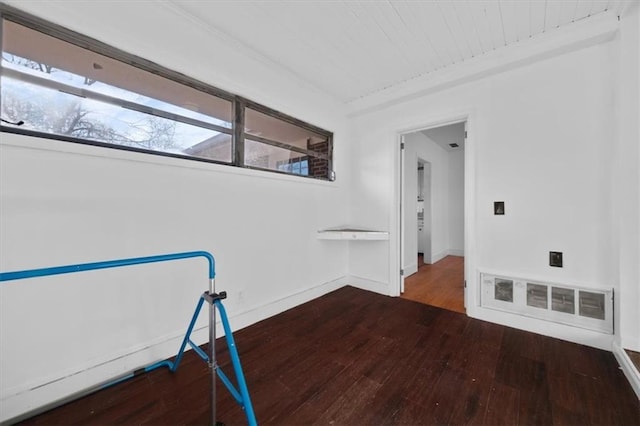 empty room with visible vents, baseboards, and wood finished floors