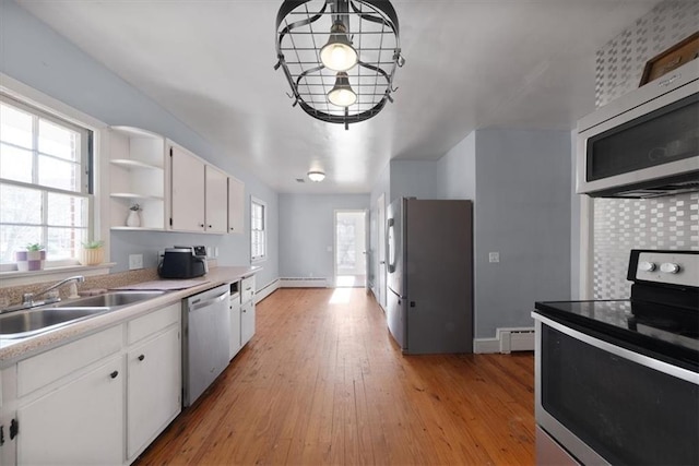 kitchen with open shelves, light countertops, appliances with stainless steel finishes, white cabinets, and a sink