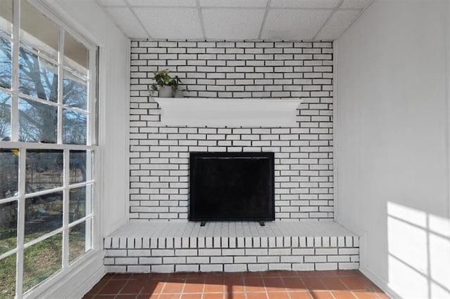 interior details with a fireplace and a drop ceiling