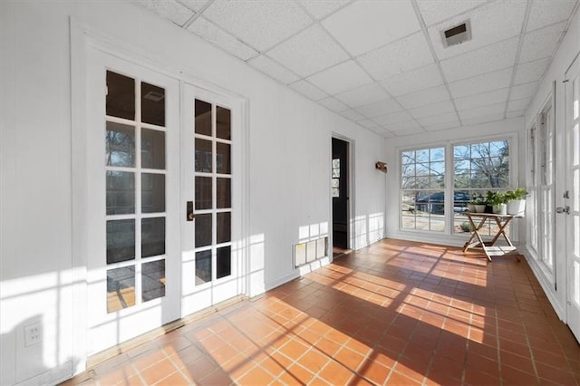 unfurnished sunroom featuring french doors, a drop ceiling, and visible vents