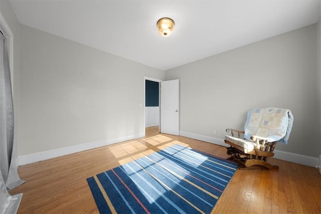 living area with baseboards and wood finished floors