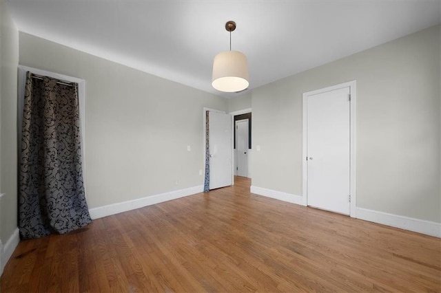 empty room with baseboards and wood finished floors