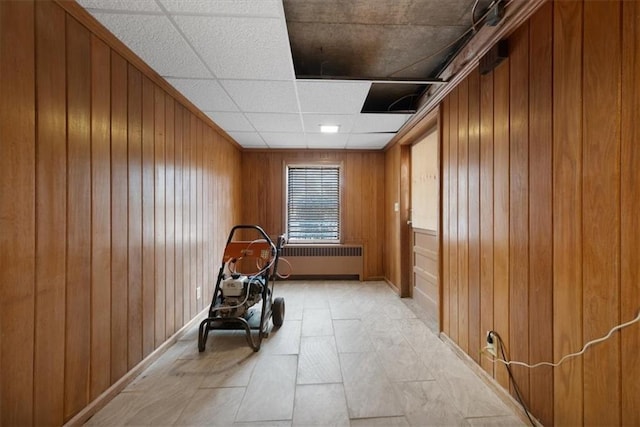 unfurnished room featuring radiator and wood walls