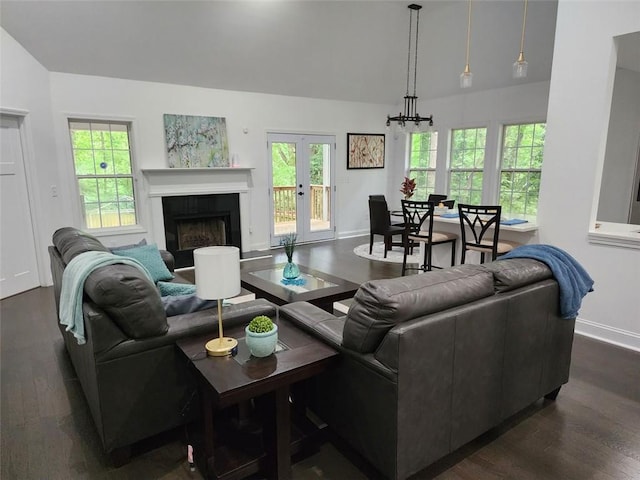 living room with french doors, dark hardwood / wood-style floors, and an inviting chandelier