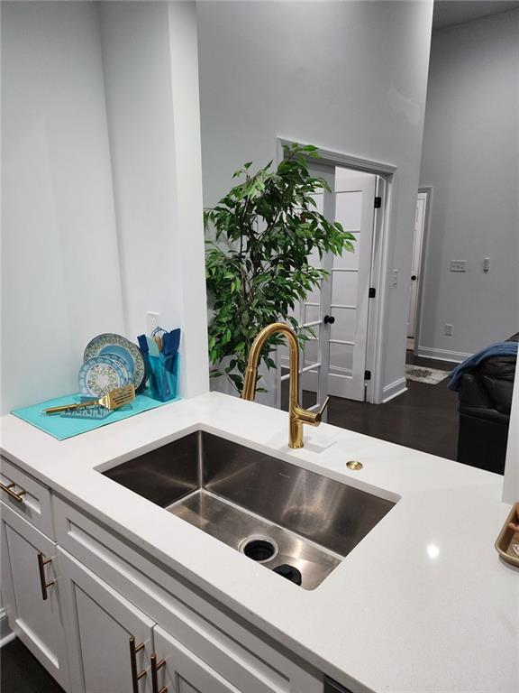 interior space with gray cabinetry, sink, and dark hardwood / wood-style flooring