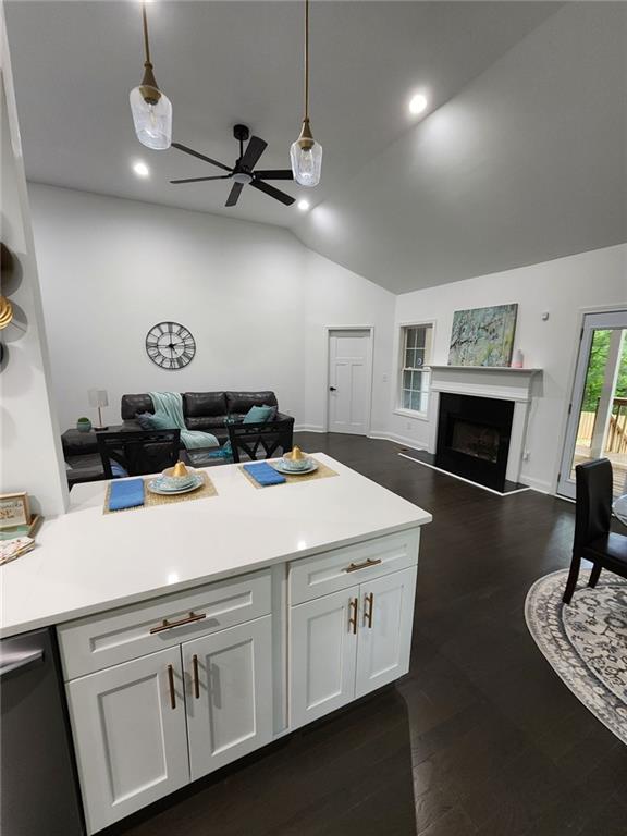 kitchen featuring dark hardwood / wood-style flooring, white cabinetry, hanging light fixtures, and vaulted ceiling