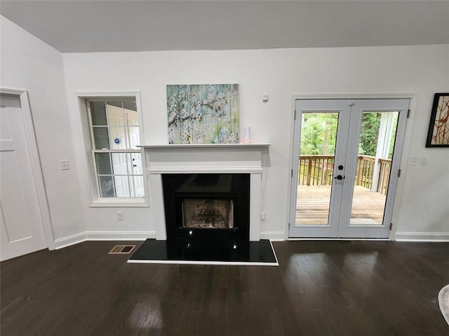 unfurnished living room featuring dark hardwood / wood-style floors and french doors