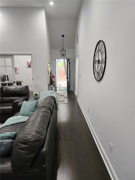 living room with high vaulted ceiling and dark hardwood / wood-style floors