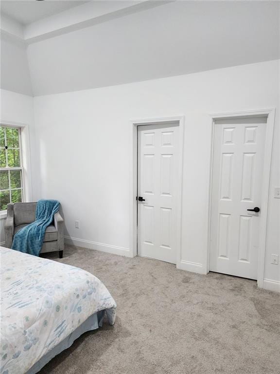 carpeted bedroom with lofted ceiling