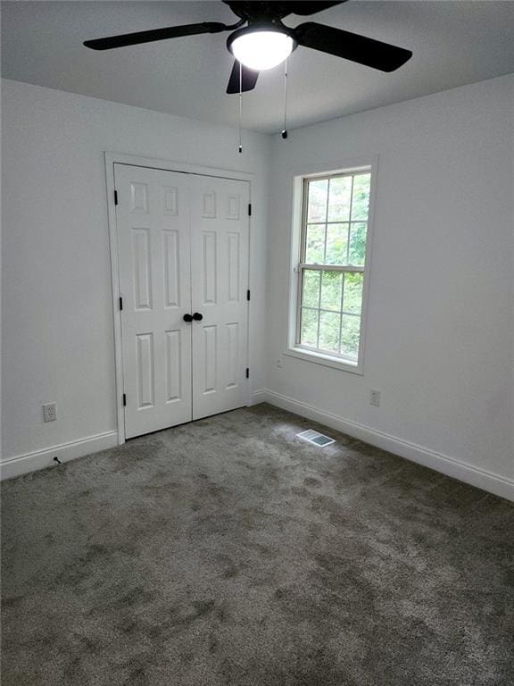 unfurnished bedroom with ceiling fan, a closet, and carpet