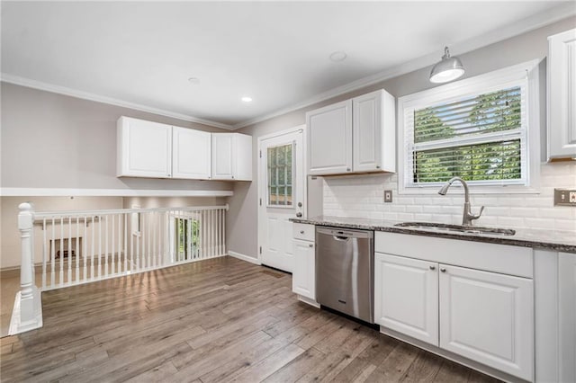 2941 Foothill Trl, Marietta, GA 30066 - kitchen with stainless steel dishwasher, dark stone counters, white cabinetry, ornamental molding, and decorative backsplash