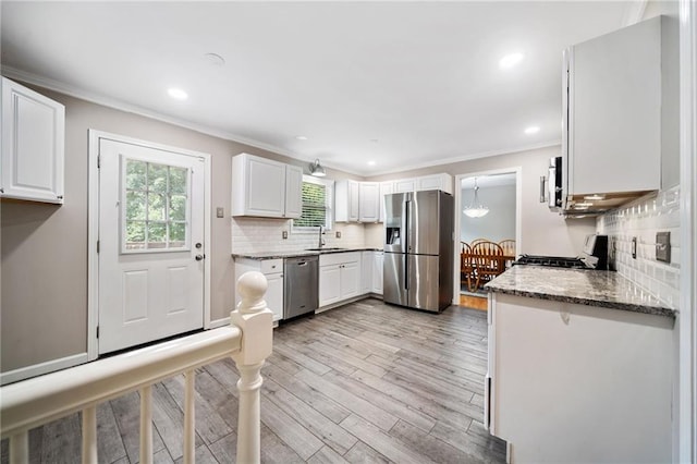 2941 Foothill Trl, Marietta, GA 30066 - kitchen with stainless steel appliances, crown molding, light wood-style floors, decorative backsplash, and white cabinets