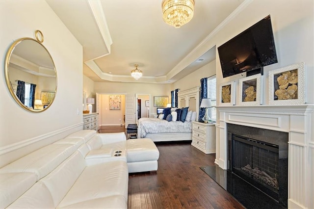 bedroom featuring ceiling fan with notable chandelier, a raised ceiling, crown molding, and dark hardwood / wood-style flooring